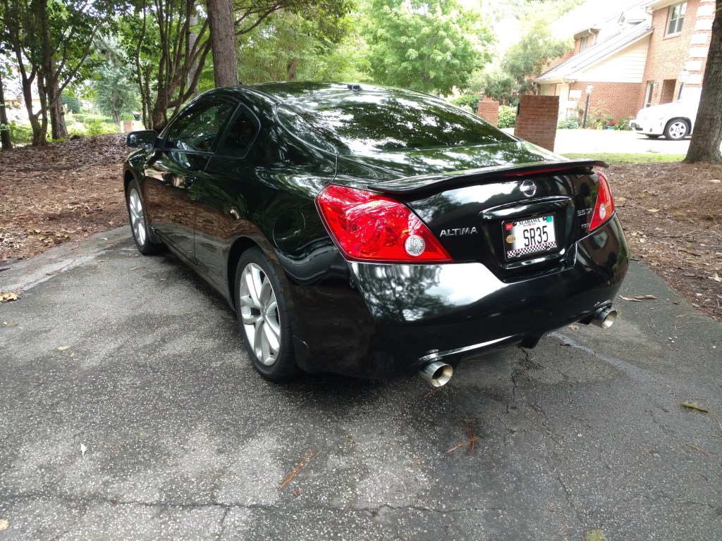 Nissan Altima pretty 3/4 rear picture Balck car in a tree shaded area
